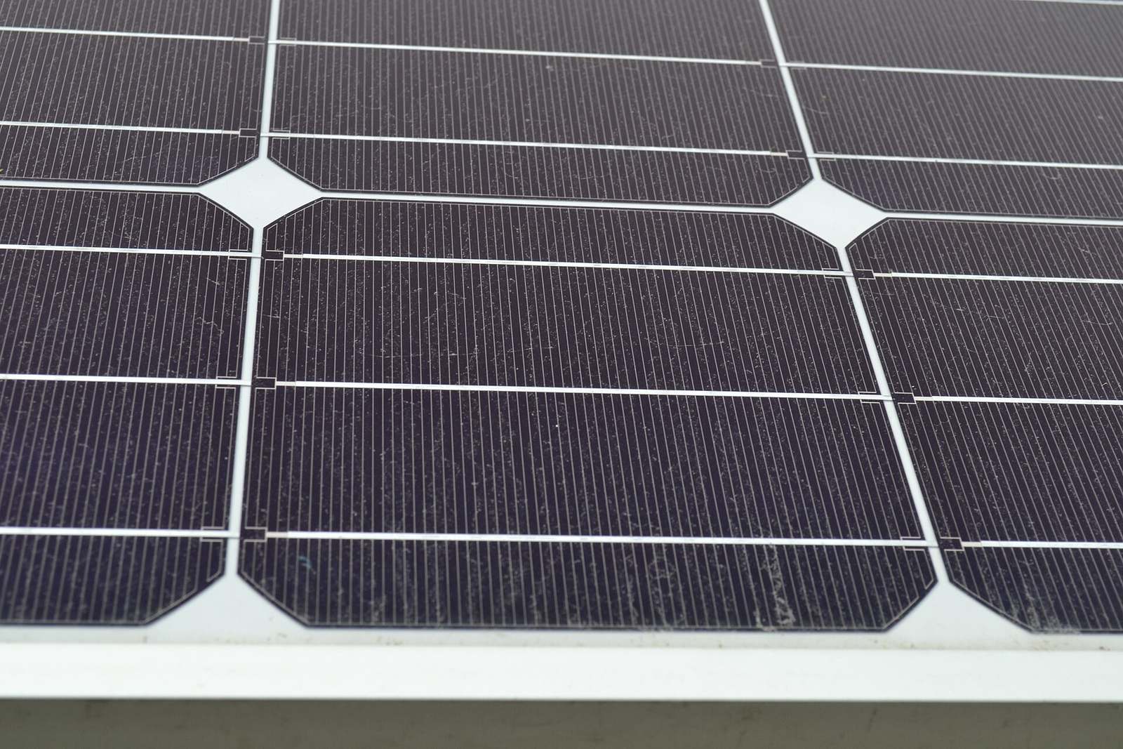 Close-up van monokristallijne zonnecellen met afgeschuinde hoeken en dunne zilveren geleiders in een paneel